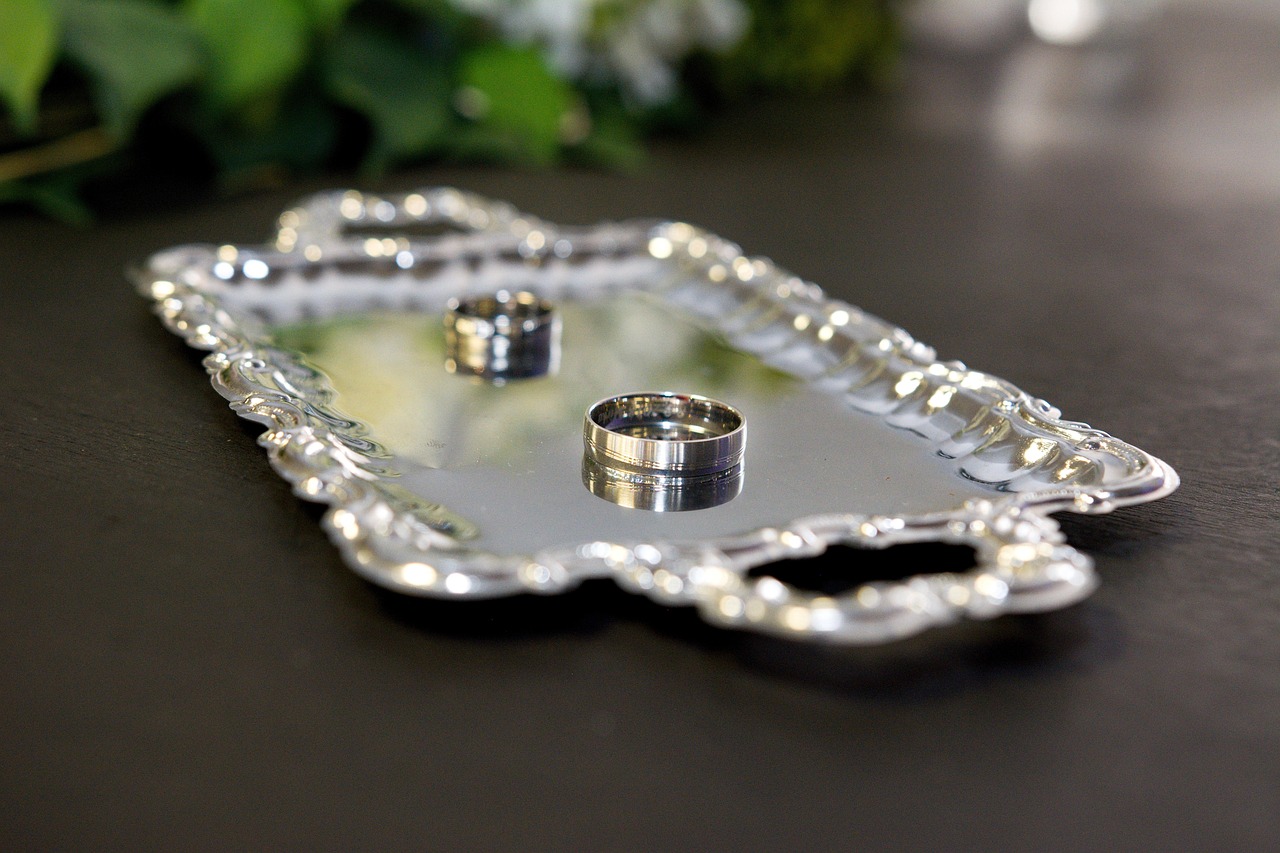 Srebrna tacka na obrączki zorganizowane przez konsultanta ślubnego w Gliwiach Kreatorkę Wspomnień. Na tacce dwie obrączki.